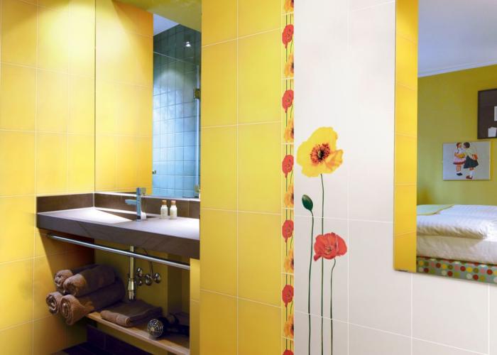Дизайн интерьера яркой ванной комнаты в желтом цвете с цветочным декором. Плитка для ванной Атем